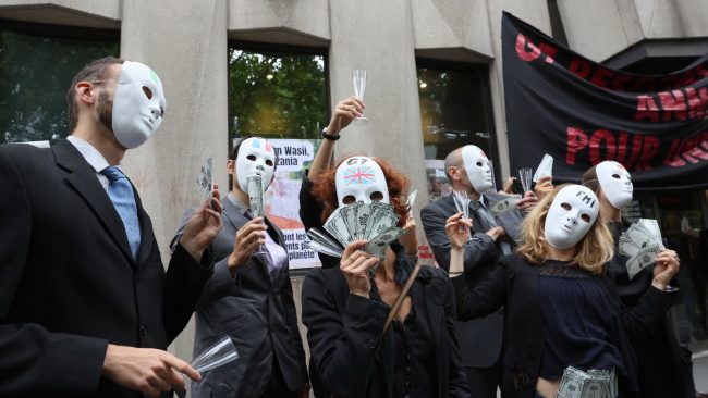 Des militants des ONG Attac, Extinction Rebellion et Youth for Climate" participent à une action dans le cadre de l'initiative "Debt for Climate", devant les locaux du FMI à Paris, le 27 juin 2022. // PHOTO : Thomas Coex / AFP