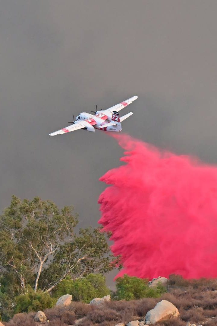 Pour ralentir les feux de forêts, les pompiers larguent du retardant, un produit à base de phosphate d’ammonium autour de l’incendie. // PHOTO : Frederic J. Brown/AFP